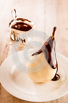 Whole fresh pears called Birne Helene with chocolate and ice-cream