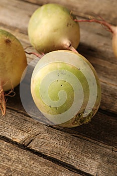 Whole fresh turnips on wooden table, closeup