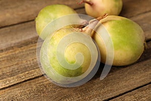 Whole fresh turnips on wooden table, closeup