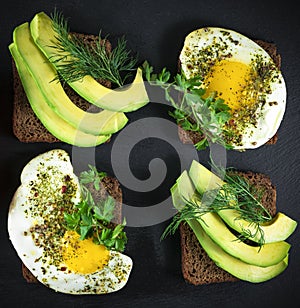 Whole grain bread sandwiches with fried quail egg, avocado, herbs and seeds