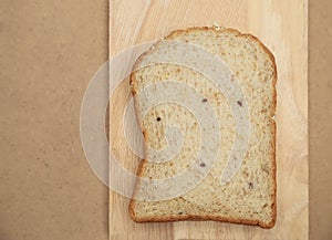 Whole grain bread on wood plate and brown texture background