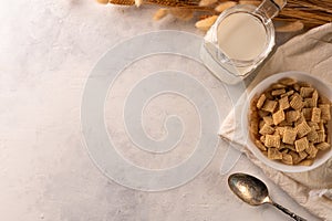 Whole grain breakfast - crispy cereal in a bowl, milk in a jug and a bunch of cereals. Isolated on a white background. There is