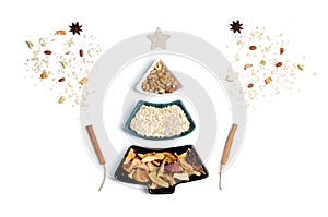 Whole grain cereals and berries in bowls in the shape of a Christmas tree with a star, as well as fireworks from dried fruits and