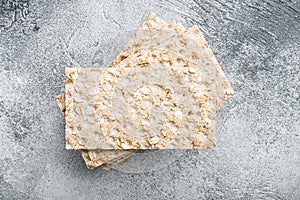 Whole grain crisp bread, on gray stone table background, top view flat lay