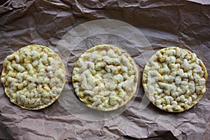 Whole grain crispbreads on craft paper texture. Crispy puffed rice or corn cakes.