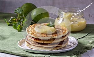 Whole grain flour fritters served with lime curd on a light background. Rustic style.