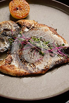 Whole grilled spicy fish served for dinner on restaurant table