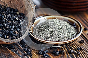 Whole and Ground black Peppercorns on old wooden table. Peppercorn Varieties. Milled black pepper. Black pepper corns and Black pe photo