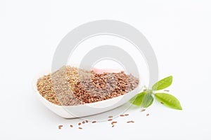 Whole and ground or crushed brown flax seed or linseed with grinder on white background