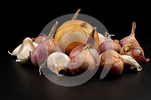 Whole group pile ingredient of fresh onion garlic isolated on black background