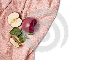 Whole, half and apple core with green leaves on fur pink towel