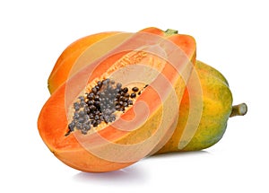 Whole and half of ripe papaya fruit with seeds on white