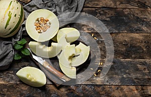 Whole, half and sliced of an Ivory gaya melon on a wooden background