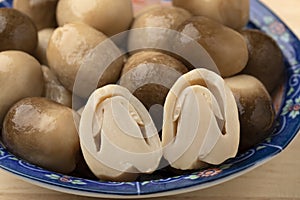 Whole and half straw mushroom in a bowl close up
