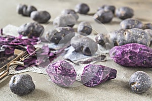 Whole and halfed peeled purple potatoes photo