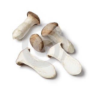 Whole and halved fresh king oyster mushrooms isolated on white background