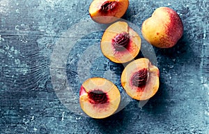 Whole and halved nectarines on rustic painted background