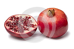 Whole and halved red ripe pomegranate isolated on white background