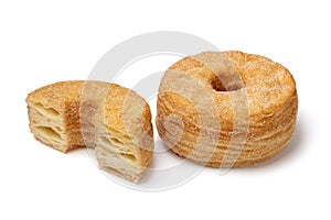 Whole and halved tasty sweet cinnamon Cronuts on white background close up