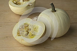 Whole and halved white Lumina pumpkins photo