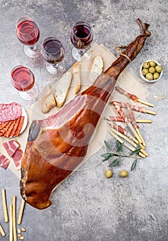 Whole leg HAM JAMON SERRANO and red and rose wine on gray background. Top view. Flat lay