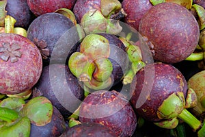 Whole mangosteen fruits on sale at a market stall