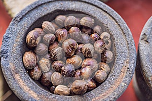 Whole nutmeg spice in dish and one open nut