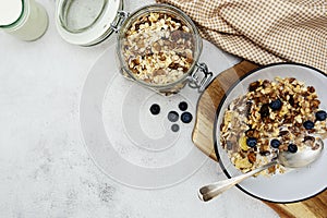Whole oats breakfast, granola with dried fruit and blueberry, milk and honey. Healthy food, clean eating. Copy space