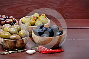 Whole olives in the wooden bowl on the table