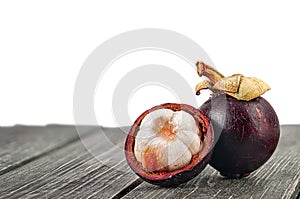 Whole and opened mangosteen on table isolated on white