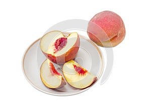 Whole peach and sliced peach on a saucer
