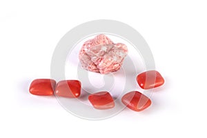 Whole pieces and chewed red bubble gum isolated over white