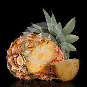 Whole pineapple and cut in half isolated on black background.