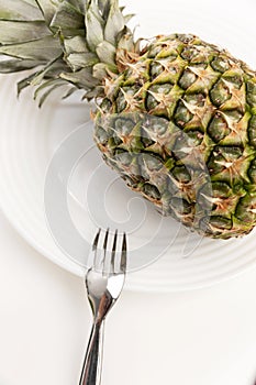 Whole pineapple on a plate. Healthy eating Close-up. White background