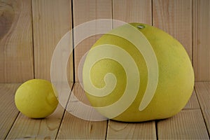 Whole pomelo and lemon on wooden background