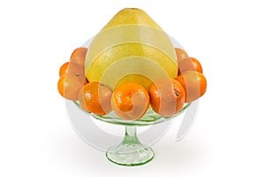 Whole pomelo and tangerines in vintage glass fruit vase