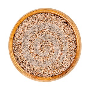 Whole psyllium seeds, Plantago ovata, in a wooden bowl