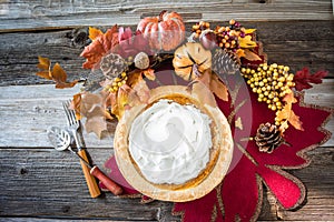 Whole pumpkin pie topped with whipped cream.