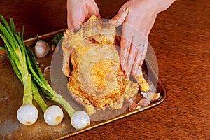 Whole raw chicken on baking paper with seasoning before cooking.