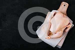 Whole Raw Chicken ready to cook. Dark background, copy space, top view