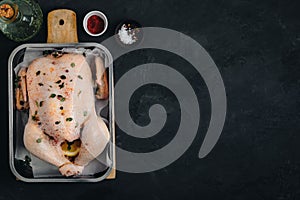 Whole Raw Chicken ready to cook. Dark background, copy space, top view