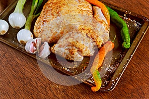 Whole raw chicken seasoned with butter and herbs for roasting. Top view,