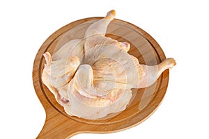 Whole raw chicken on wooden cutting board isolated on white background