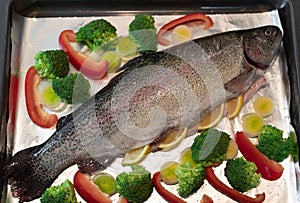 whole raw rainbow trout with broccoli, leek, red pepper and spices