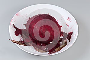 Whole raw peeled red beetroot among the peelings in bowl photo