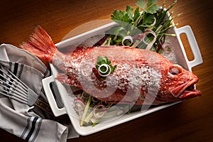 Whole red fish with sea salt and herbs