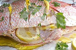 whole red snapper with lemon slices and parsley