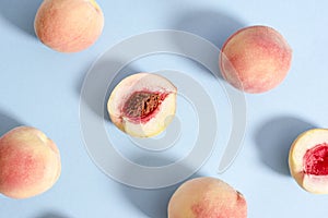 Whole ripe beautiful peaches and one split in half with putamen photo
