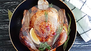 Whole roast chicken, branch of a Christmas tree, candle on a wooden background slow-motion