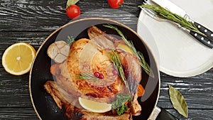 Whole roast chicken garlic lemon, holiday food roasted glazed delicious on a wooden background slow-motion